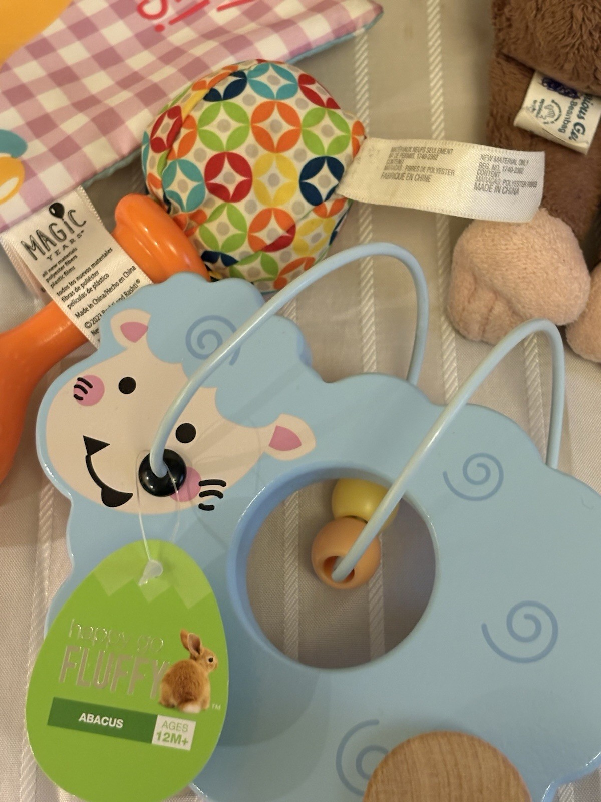 collection of infant clothing and toys, including branded